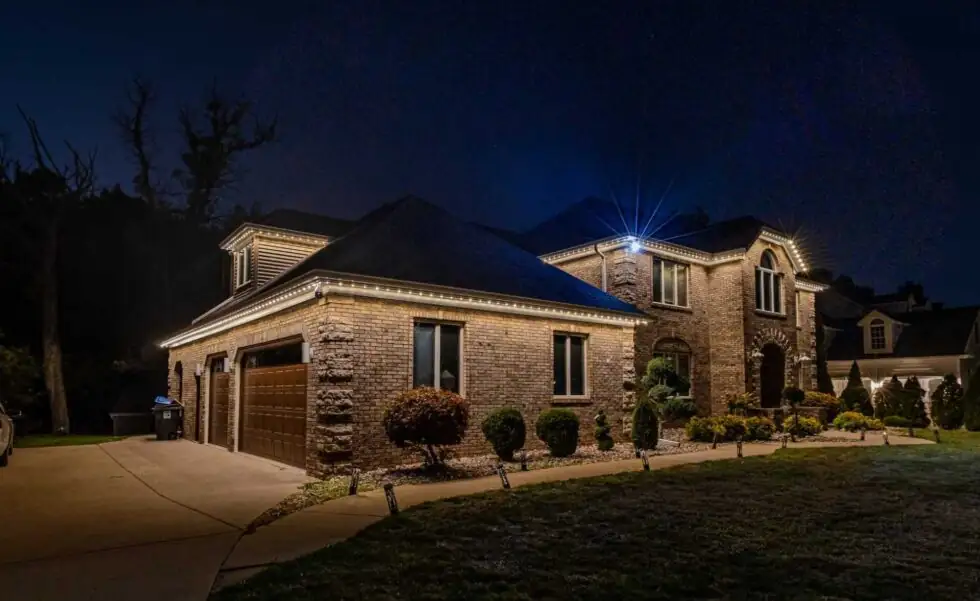 Warm white roofline Christmas lights with blue accent lighting on an Atlanta-area home.