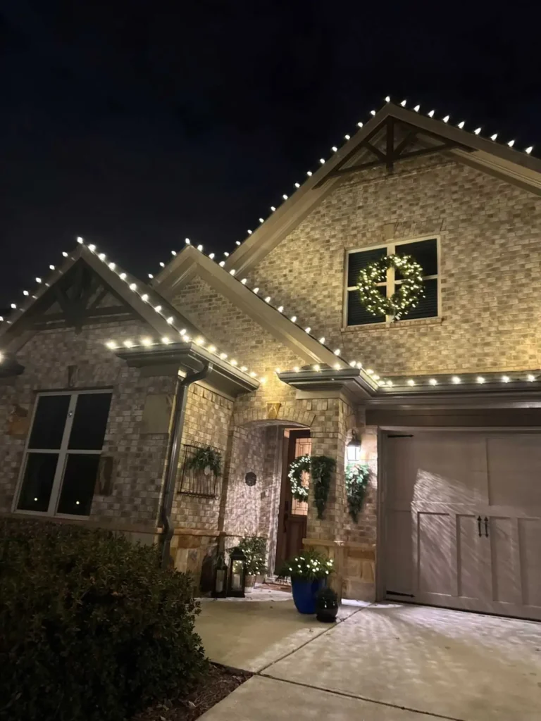 Christmas wreath and warm white roofline lights installed on an Atlanta-area home.